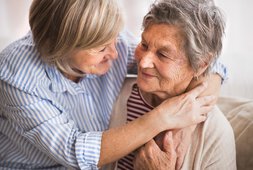 Zwei ältere Frauen zuhause die sich umarmen | © Halfpoint - Fotolia